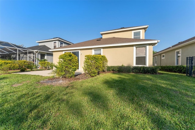 exterior space featuring stucco siding and a lawn
