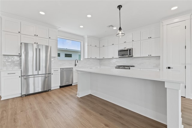 11 29th St N, Saint Petersburg, FL 33713 - kitchen featuring light countertops, appliances with stainless steel finishes, a sink, and white cabinetry