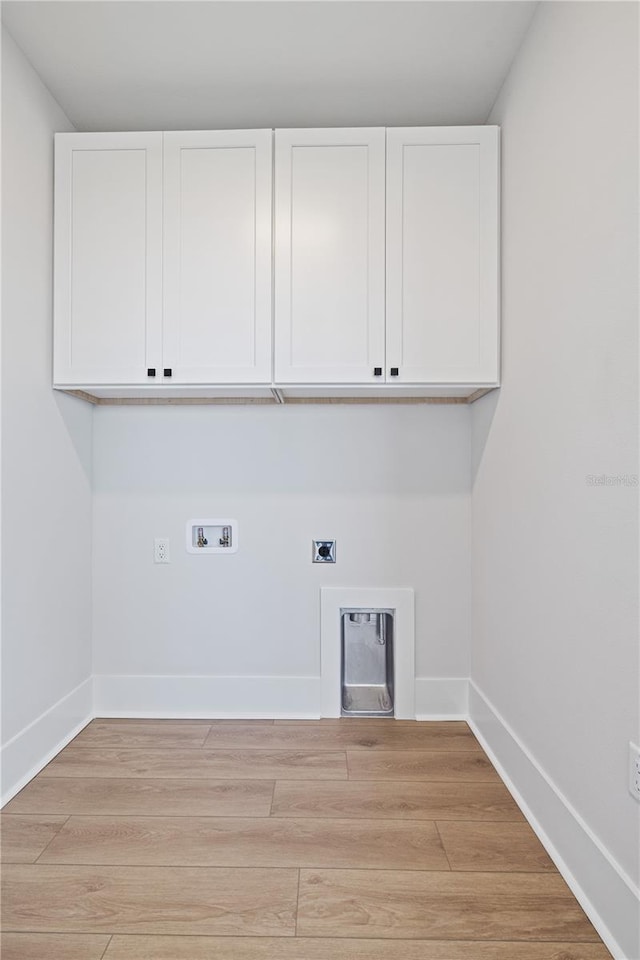 11 29th St N, Saint Petersburg, FL 33713 - washroom with baseboards, washer hookup, hookup for an electric dryer, light wood finished floors, and cabinet space
