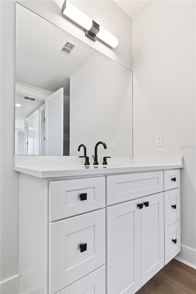 11 29th St N, Saint Petersburg, FL 33713 - bathroom with vanity, visible vents, baseboards, and wood finished floors