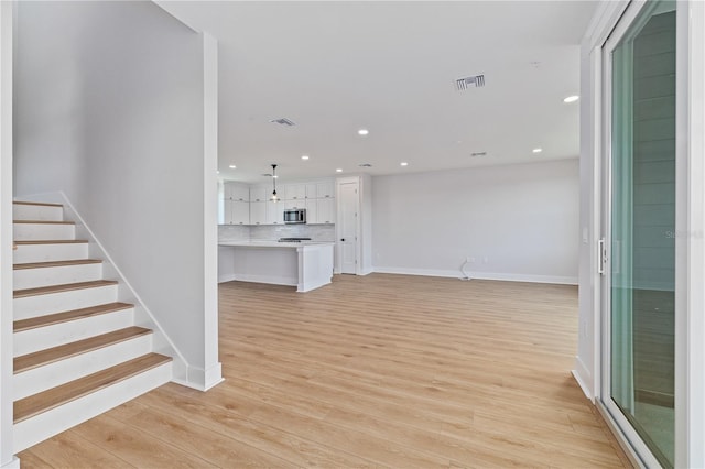 11 29th St N, Saint Petersburg, FL 33713 - unfurnished living room with visible vents, baseboards, light wood finished floors, and recessed lighting