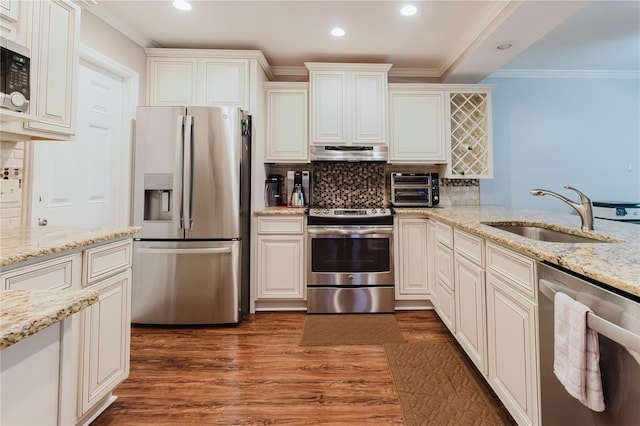 kitchen featuring recessed lighting, extractor fan, stainless steel appliances, and a sink