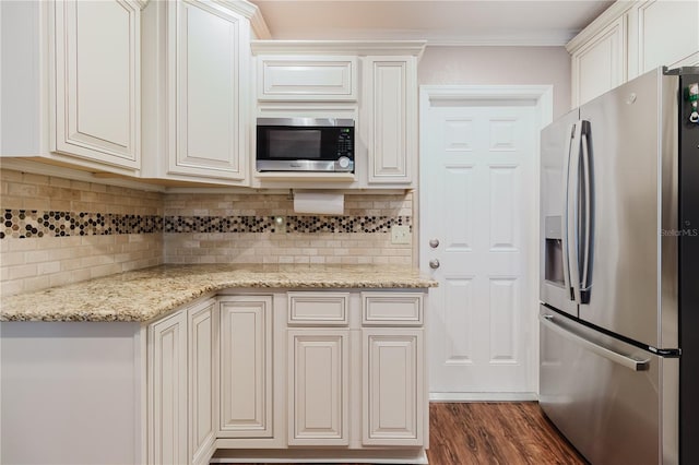 kitchen with light stone countertops, stainless steel appliances, backsplash, and dark wood finished floors