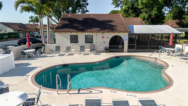 community pool with a sunroom and a patio