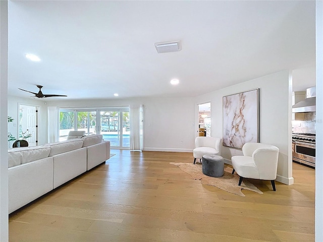 living room featuring visible vents, ceiling fan, baseboards, recessed lighting, and light wood finished floors