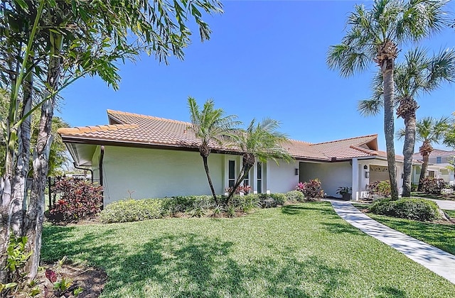773 Snug Is, Clearwater Beach, FL 33767 - view of front of home featuring stucco siding, a front yard, and a tiled roof