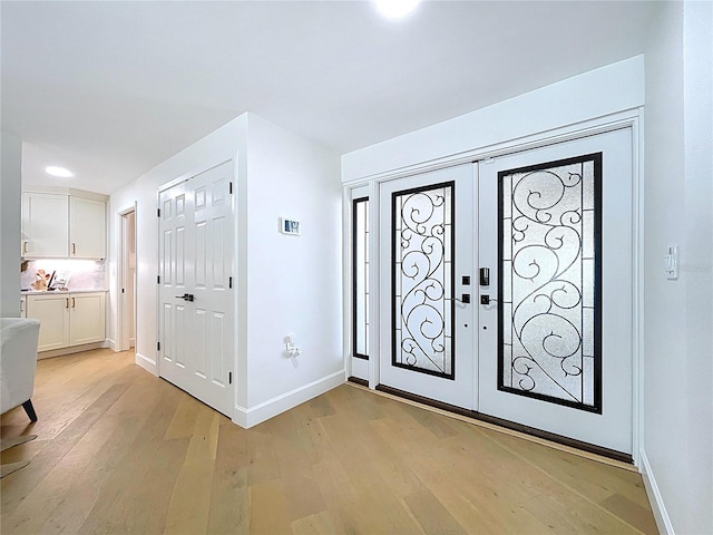 773 Snug Is, Clearwater Beach, FL 33767 - foyer with light wood finished floors, baseboards, and french doors