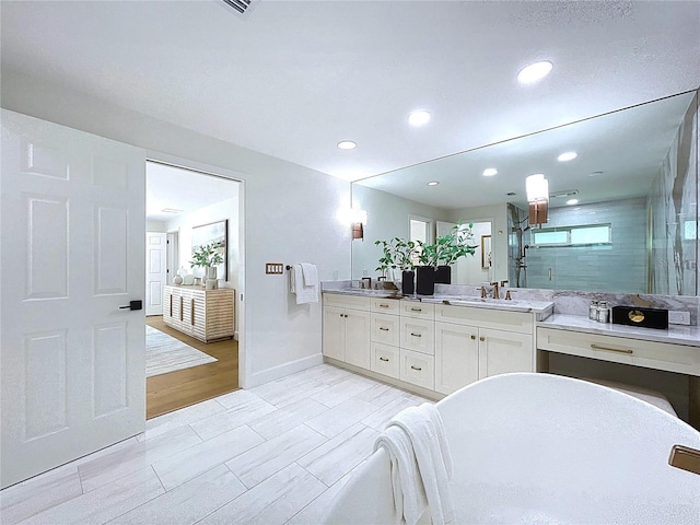 773 Snug Is, Clearwater Beach, FL 33767 - bathroom featuring a stall shower, double vanity, a freestanding tub, recessed lighting, and baseboards