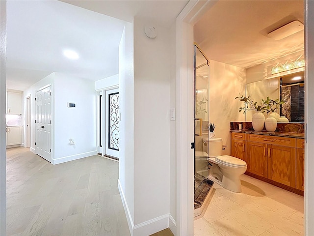 773 Snug Is, Clearwater Beach, FL 33767 - bathroom featuring toilet, vanity, baseboards, and wood finished floors