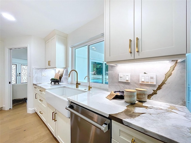 773 Snug Is, Clearwater Beach, FL 33767 - kitchen featuring stainless steel dishwasher, light wood-style floors, white cabinets, a sink, and tasteful backsplash