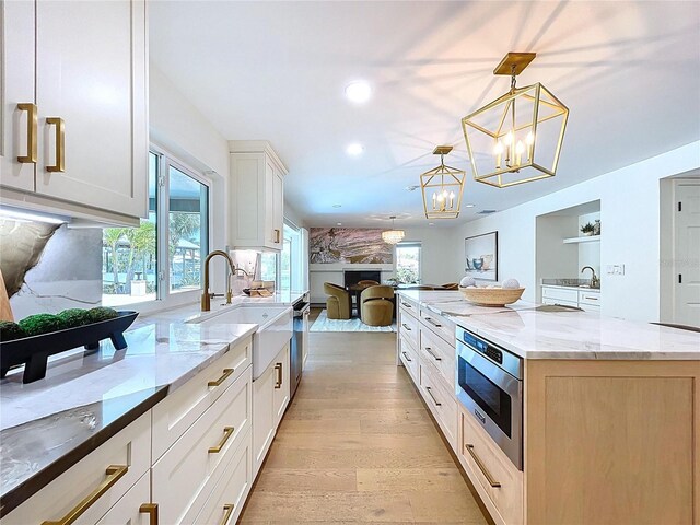 773 Snug Is, Clearwater Beach, FL 33767 - kitchen featuring a sink, open floor plan, light wood finished floors, recessed lighting, and light stone countertops