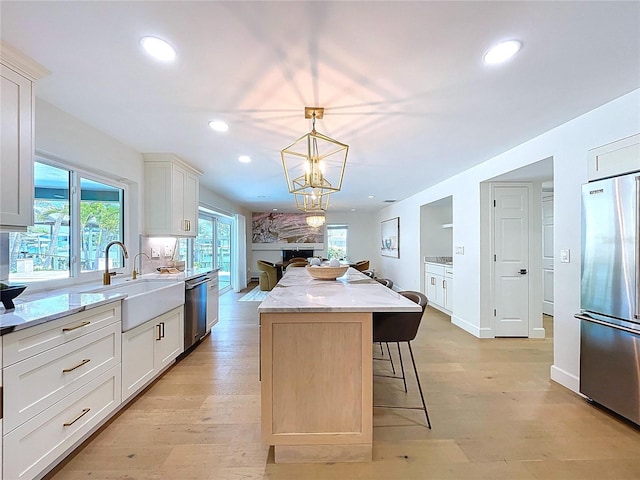 773 Snug Is, Clearwater Beach, FL 33767 - kitchen with appliances with stainless steel finishes, a center island, a sink, recessed lighting, and a breakfast bar