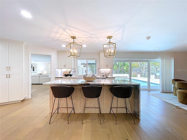 773 Snug Is, Clearwater Beach, FL 33767 - kitchen featuring white cabinetry, light wood finished floors, recessed lighting, a kitchen island, and decorative light fixtures