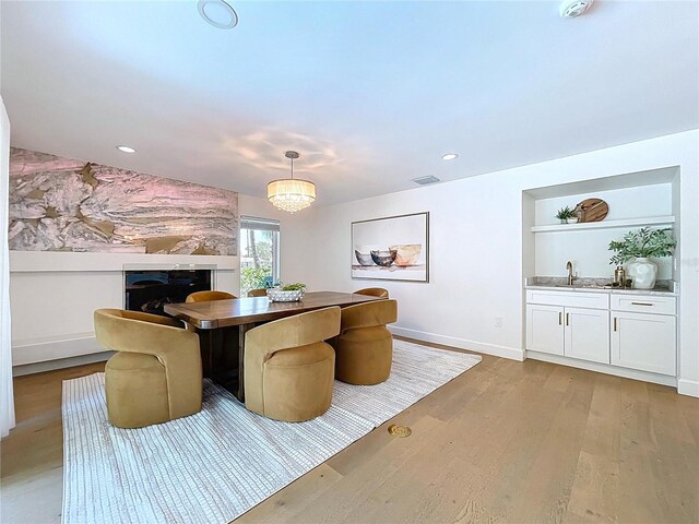 773 Snug Is, Clearwater Beach, FL 33767 - dining room featuring light wood-type flooring, wet bar, built in shelves, a fireplace, and baseboards