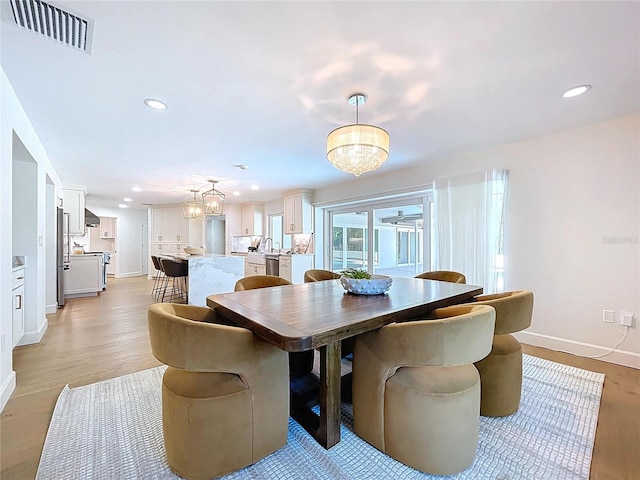 773 Snug Is, Clearwater Beach, FL 33767 - dining room featuring a chandelier, baseboards, light wood-type flooring, and recessed lighting