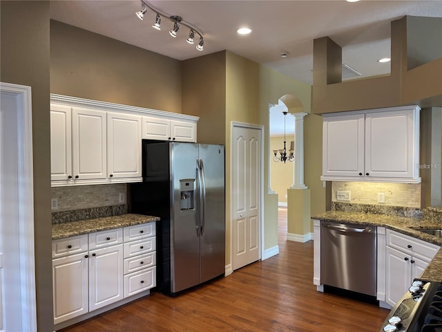 kitchen with white cabinets, stainless steel appliances, decorative backsplash, and ornate columns