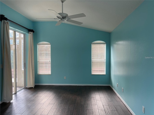 empty room featuring a ceiling fan, baseboards, vaulted ceiling, and dark wood-type flooring