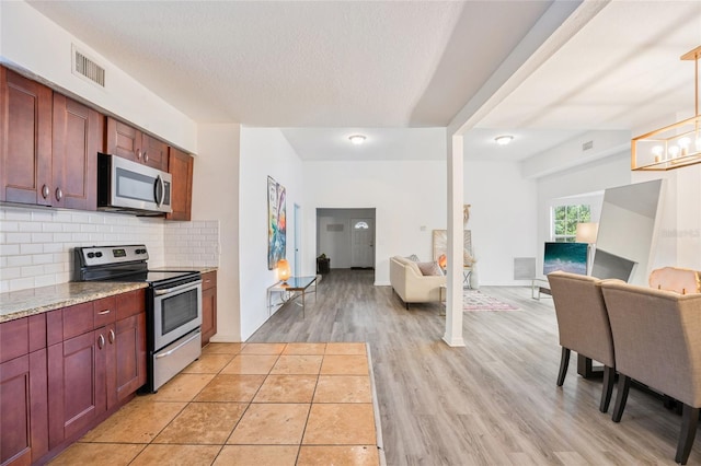 105 W Columbus Dr, Tampa, FL 33602 - kitchen with tasteful backsplash, light wood-type flooring, open floor plan, visible vents, and appliances with stainless steel finishes