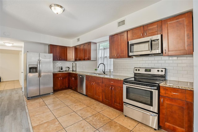 105 W Columbus Dr, Tampa, FL 33602 - kitchen featuring stainless steel appliances, light stone countertops, visible vents, and a sink