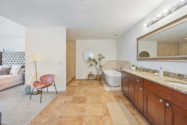 105 W Columbus Dr, Tampa, FL 33602 - full bathroom featuring a sink, double vanity, a freestanding tub, and a textured ceiling