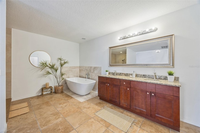 105 W Columbus Dr, Tampa, FL 33602 - full bath featuring a soaking tub, a textured ceiling, visible vents, a sink, and double vanity