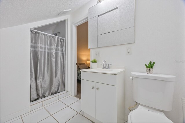105 W Columbus Dr, Tampa, FL 33602 - bathroom with a shower with shower curtain, vanity, tile patterned floors, a textured ceiling, and toilet