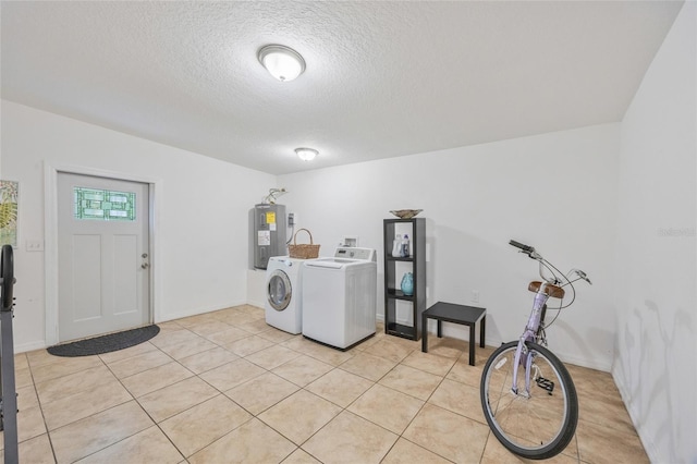 105 W Columbus Dr, Tampa, FL 33602 - washroom featuring electric water heater, a textured ceiling, light tile patterned flooring, laundry area, and washing machine and clothes dryer