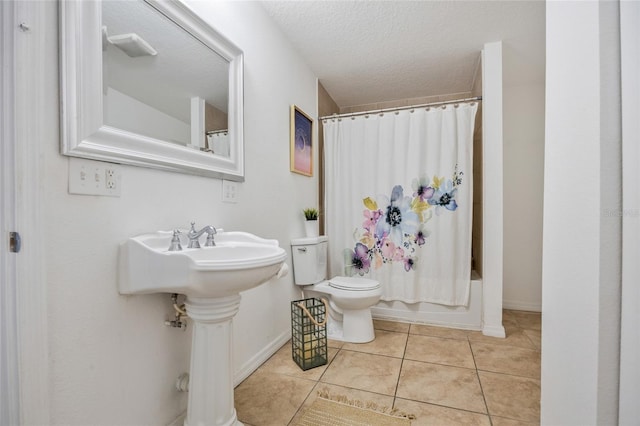 105 W Columbus Dr, Tampa, FL 33602 - bathroom featuring tile patterned flooring, baseboards, a textured ceiling, and toilet