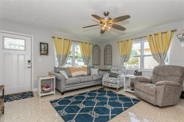 living room with baseboards, speckled floor, and a ceiling fan