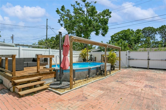 view of patio / terrace with a fenced backyard, a wooden deck, a fenced in pool, and a gate