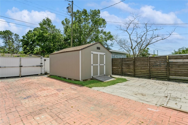 view of shed with a fenced backyard and a gate