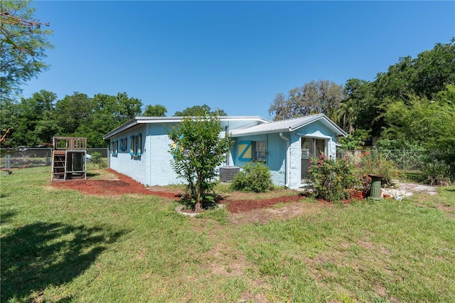 17111 Mockingbird Ln, Lutz, FL 33548 - view of front facade with a front lawn, fence, cooling unit, and metal roof