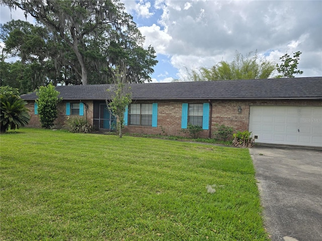 ranch-style home with driveway, an attached garage, a front lawn, brick siding, and a shingled roof
