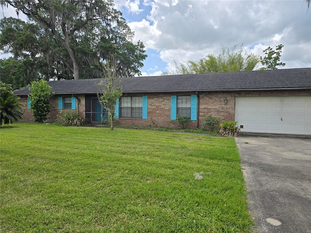 single story home featuring a garage, a front yard, brick siding, and driveway