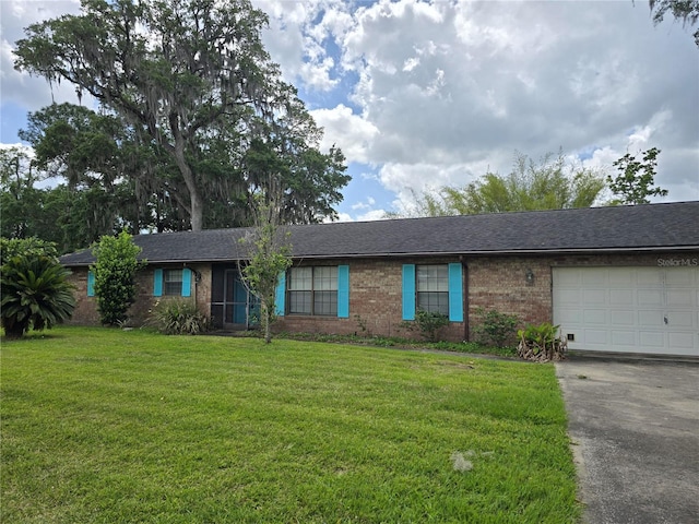ranch-style home with a garage, a front yard, aphalt driveway, and brick siding