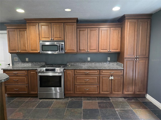 kitchen featuring stainless steel appliances, recessed lighting, baseboards, and stone tile flooring