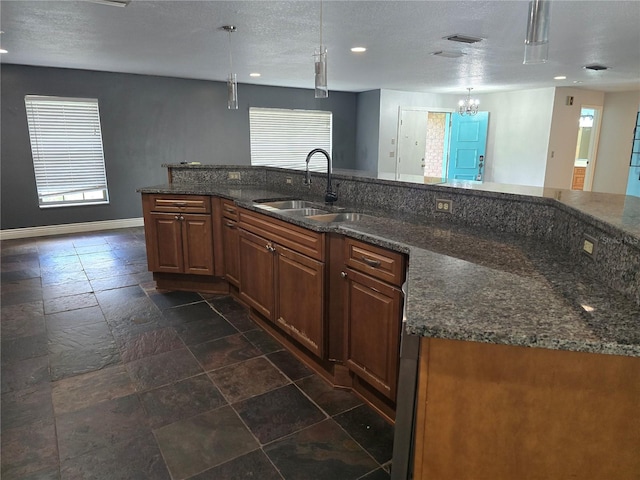 kitchen featuring a textured ceiling, a sink, and recessed lighting