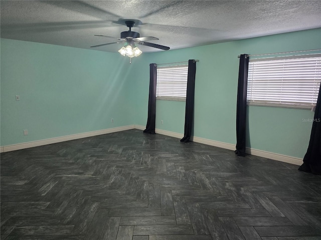 empty room featuring a textured ceiling, baseboards, and ceiling fan