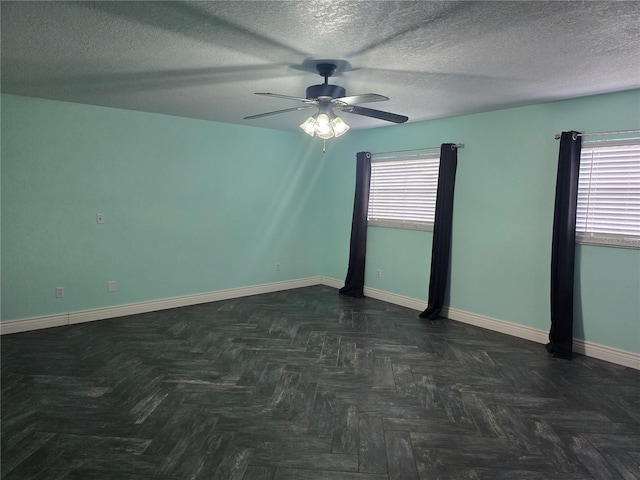 empty room featuring baseboards, a ceiling fan, and a textured ceiling