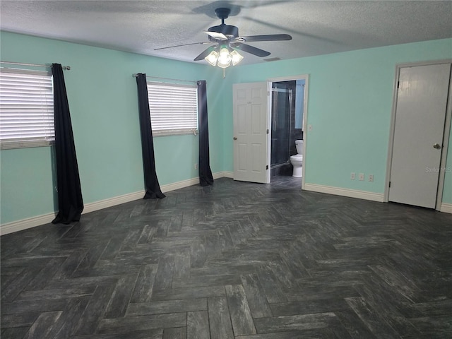 unfurnished bedroom featuring baseboards, ensuite bath, a textured ceiling, visible vents, and ceiling fan