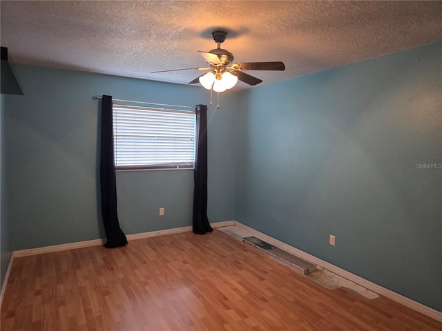 unfurnished room featuring ceiling fan, baseboards, wood finished floors, and a textured ceiling
