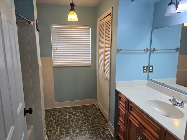 full bath with tile patterned floors, walk in shower, vanity, and baseboards