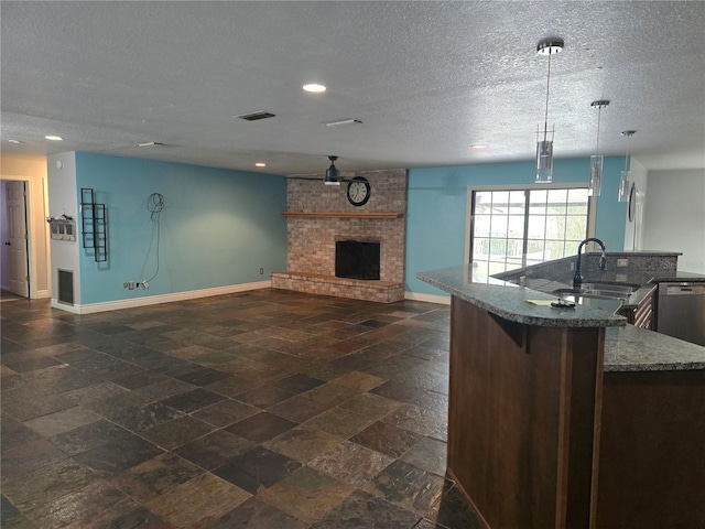 kitchen with a sink, open floor plan, baseboards, and visible vents