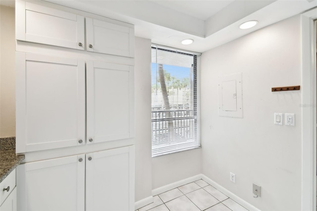 interior space with light tile patterned floors, baseboards, recessed lighting, and electric panel