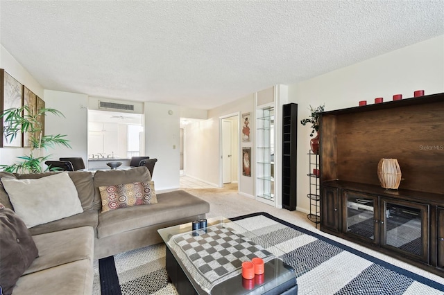 carpeted living room with a textured ceiling, baseboards, and visible vents