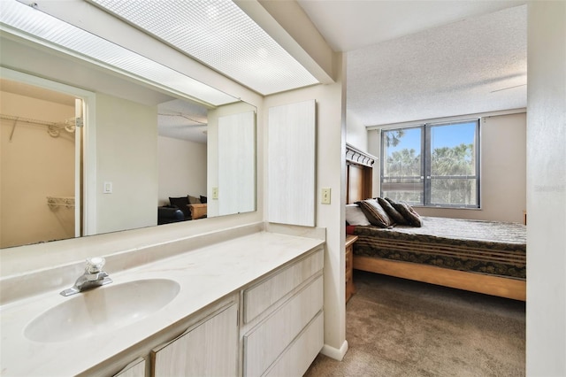 bedroom featuring light colored carpet, a sink, and a spacious closet