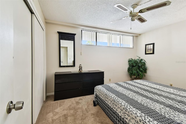 carpeted bedroom featuring a closet, a textured ceiling, and a ceiling fan