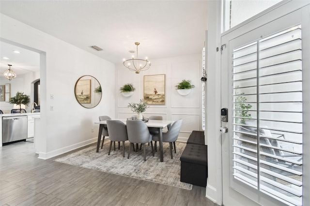 10011 Parley Dr, Tampa, FL 33626 - dining room with baseboards, a chandelier, visible vents, arched walkways, and wood finished floors