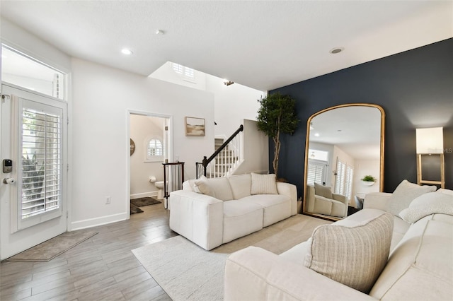 10011 Parley Dr, Tampa, FL 33626 - living room featuring stairway, light wood-type flooring, baseboards, and a healthy amount of sunlight
