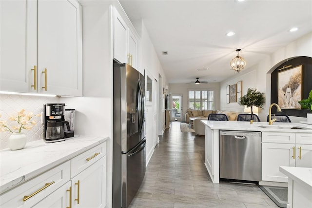 10011 Parley Dr, Tampa, FL 33626 - kitchen featuring fridge with ice dispenser, white cabinets, decorative backsplash, stainless steel dishwasher, and a sink